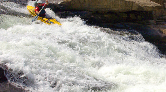 A kayaker rides down the rapids at Valley Falls State Park.