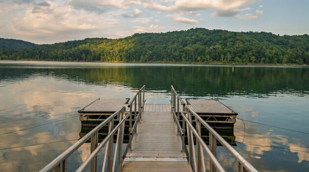 A dock opens up to a beautiful lake enclosed by West Virginia mountains.