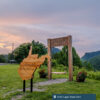 An Almost Heaven swing and sign sits at Chief Logan State Park at sunset.