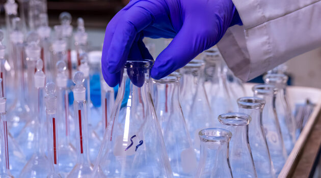 Chemours Belle Plant. A gloved hand carefully grabs some glassware.