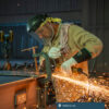A worker grinds metal at Parkline Inc.
