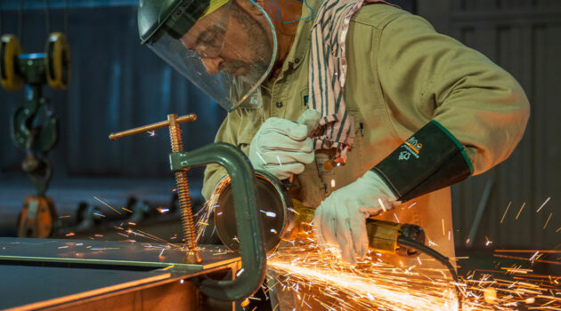 A worker grinds metal at Parkline Inc.